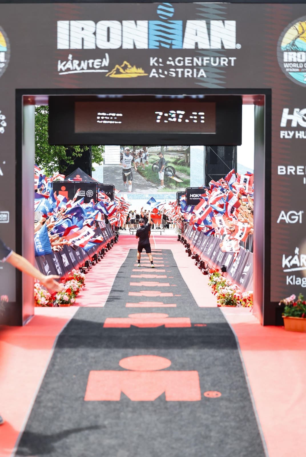 Athlete celebrating in the finish chute of an Ironman race